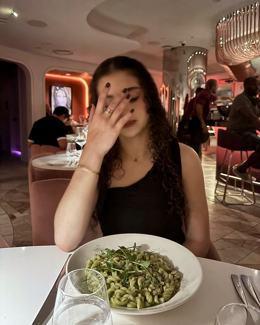 At a restaurant, hand to face.