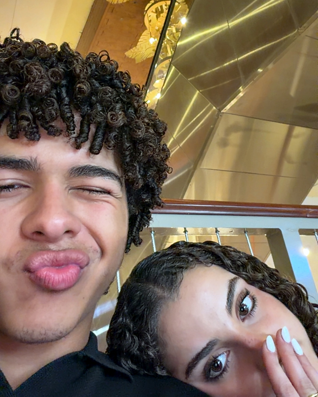 Noah pulling a face, Elena hiding behind her hand.